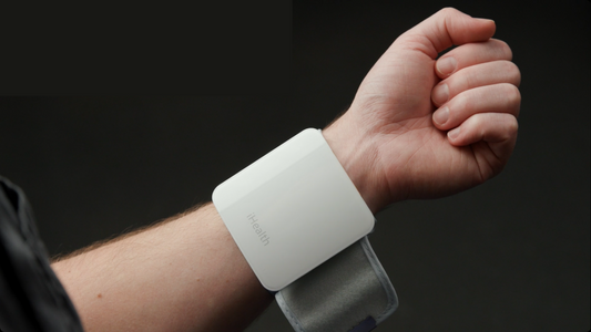 A white blood pressure wrist cuff on a man's wrist. 