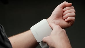 A man unboxes a blood pressure wrist cuff, places it on his wrist, and presses the button to take his blood pressure.